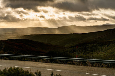 Road by mountains against sky