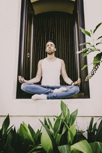 Man sitting by potted plants