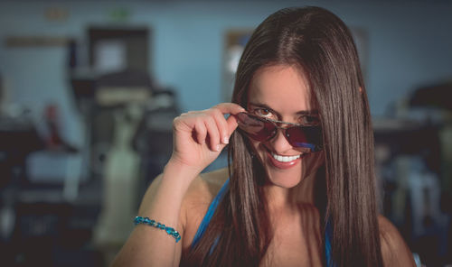 Close-up of young woman looking over sunglasses