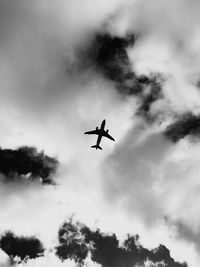 Low angle view of airplane flying against sky