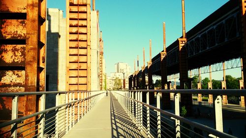 Bridge by buildings against sky in city