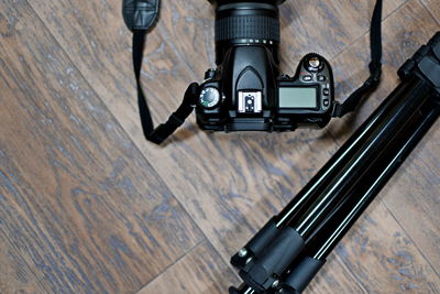 Directly above shot of dslr camera with tripod on wooden table