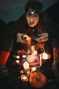 Close up grimacing woman shaman peeling apple above pot portrait picture