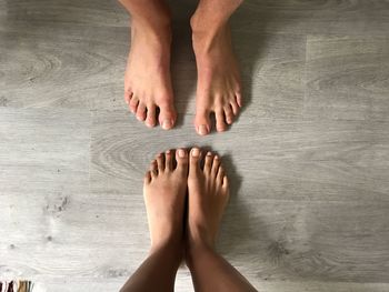 Low section of people standing on hardwood floor