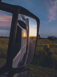 Close-up of road on field against sky during sunset