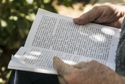 Midsection of man holding book