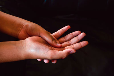 Close-up of person hand against black background