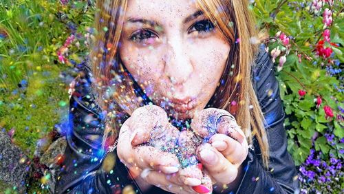 High angle portrait of woman blowing glitter