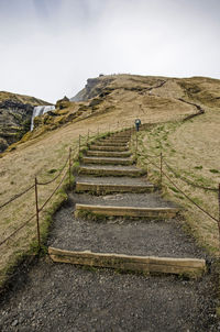 Staircase leading uphill to waterfall skogafoss