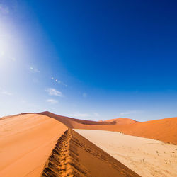 Scenic view of desert against blue sky