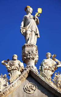 Statues and carvings on saint mark basilica against clear blue sky