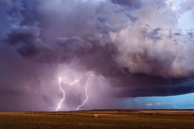 View of lightning over landscape against storm clouds