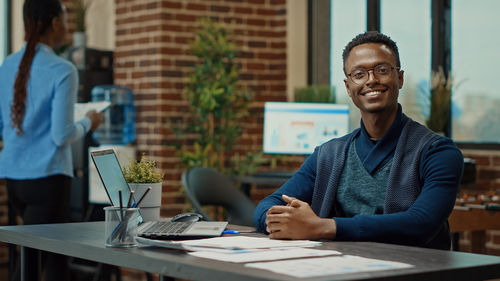 Portrait of man using mobile phone in office