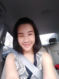 Portrait of smiling young woman sitting in car