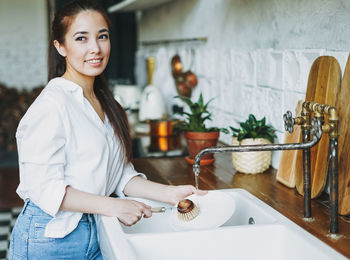 Portrait of smiling woman standing at home