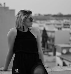 Young woman looking away while sitting outdoors