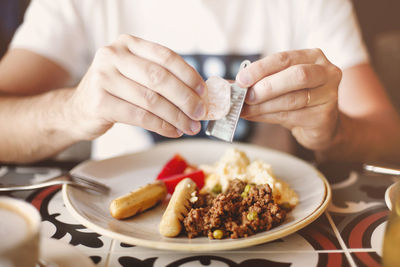 Midsection of person having food in plate