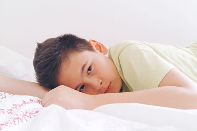 Portrait of cute boy resting on bed at home