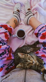 Low section of man with coffee cup on bed