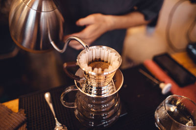 Cropped hand of man making coffee