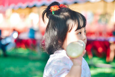 Close-up of girl blowing bubbles at home