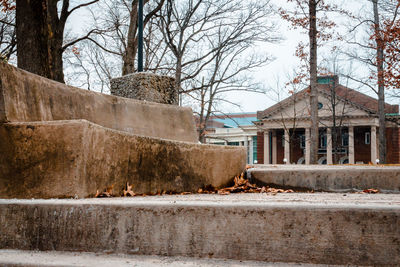 View of old building by bare trees in winter