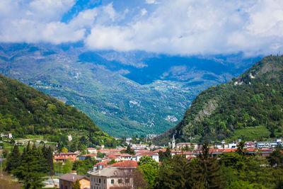 Scenic view of townscape and mountains against sky