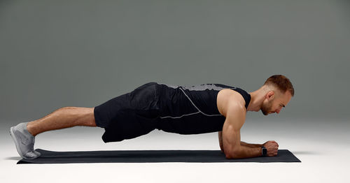 Low section of woman exercising against clear sky