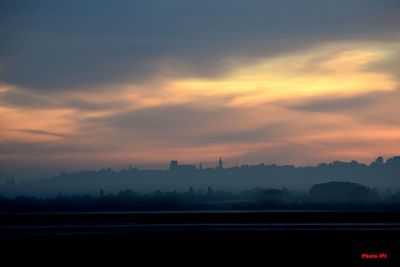 Scenic view of silhouette city against sky during sunset