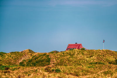 Sand dune and a holiday home on the island of juist, germany.