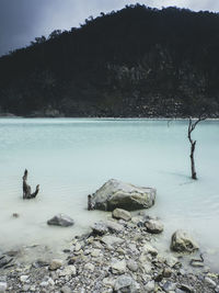 Scenic view of rocks by lake during winter