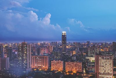 Illuminated buildings in city against sky