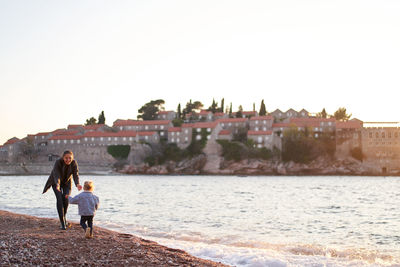 Rear view of people walking at beach