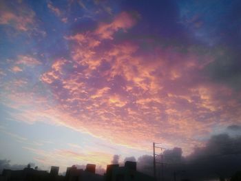 Low angle view of buildings against cloudy sky