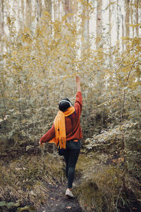 Rear view of woman standing in forest