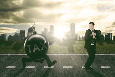 Digital composite image of explosive equipment running towards businessman in city during sunset