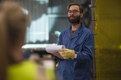 Man with clipboard in factory