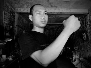 Portrait of young man standing against wall