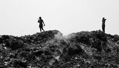 Man standing on rock against clear sky