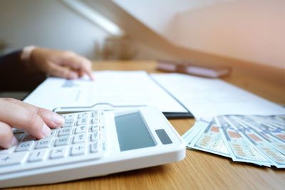 Midsection of businessman using calculator at office