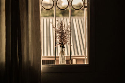 Flowers in vase on window sill at home