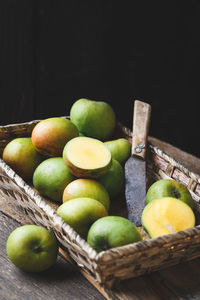 Close-up of fruits in basket against black background