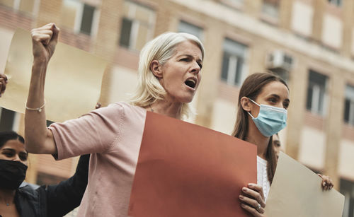 Portrait of smiling couple with hands in city