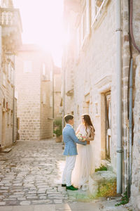 Full length of couple standing amidst alley