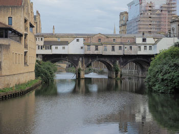 Arch bridge over river against sky