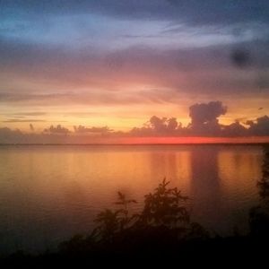 Scenic view of lake against sky at sunset