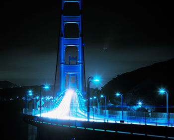 Illuminated road against sky at night