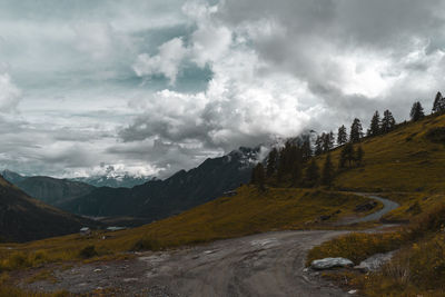 Road by mountains against sky