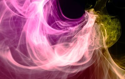 Close-up of multi colored smoke against black background