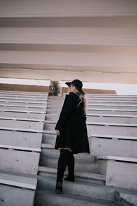 Side view of young man standing on staircase